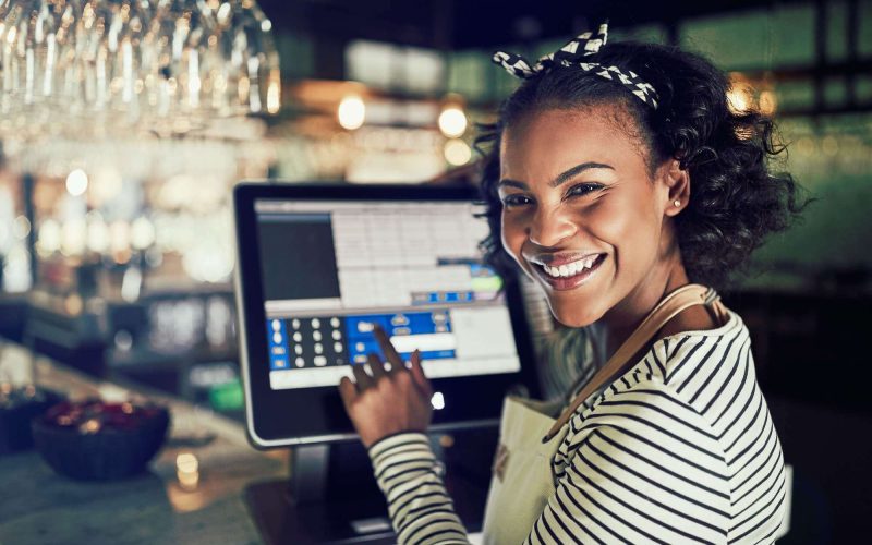 smiling-african-waitress-using-a-restaurant-point-of-sale-terminal-1.jpg